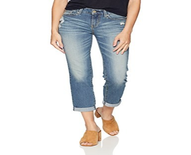 Frau in schwarzem T-Shirt und Levi's Women's 721 High Rise Straight Leg Jeans auf einer weißen Oberfläche stehend.