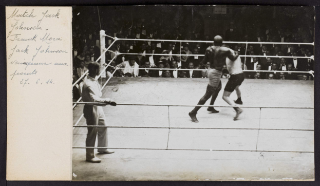 Schwarz-weiß-Foto von zwei Boxern, einem Ringrichter und Zuschauern in einem Boxring, mit "Jack Johnson vs Frank Morgan"-Text in der linken oberen Ecke.