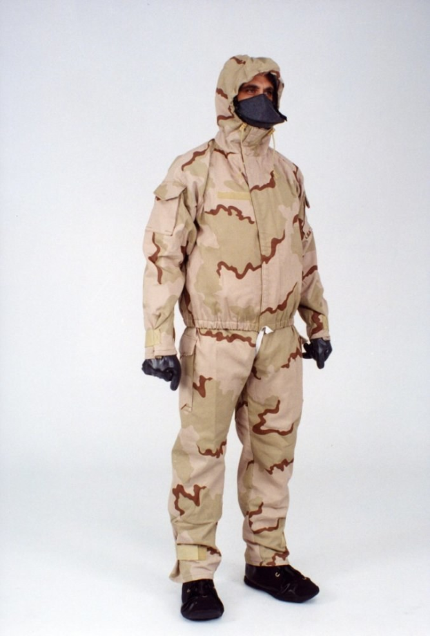 Mann in einem Tarnmuster-Schutzoverall mit Kapuze und Maske vor einem weißen Hintergrund.