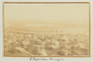 Altes Schwarz-Weiß-Foto eines Stadions in einer städtischen Umgebung, umgeben von Gebäuden, Bäumen und Strommasten, mit Text am unteren Rand.