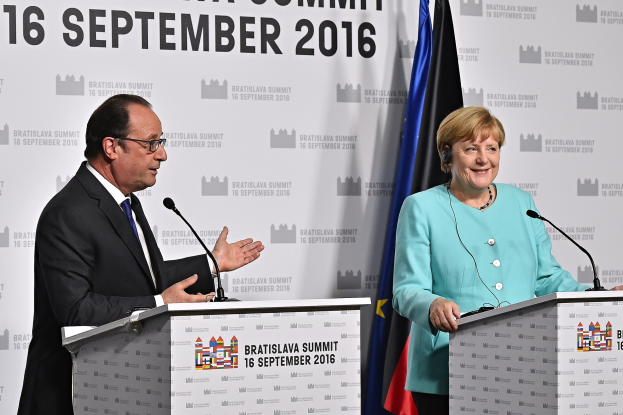 Bundeskanzlerin Angela Merkel und Frankreichs Präsident François Hollande stehen an Podien mit Mikrofonen, sie lächeln, mit einem "Bratislava-Gipfel 2016"-Schild dahinter.