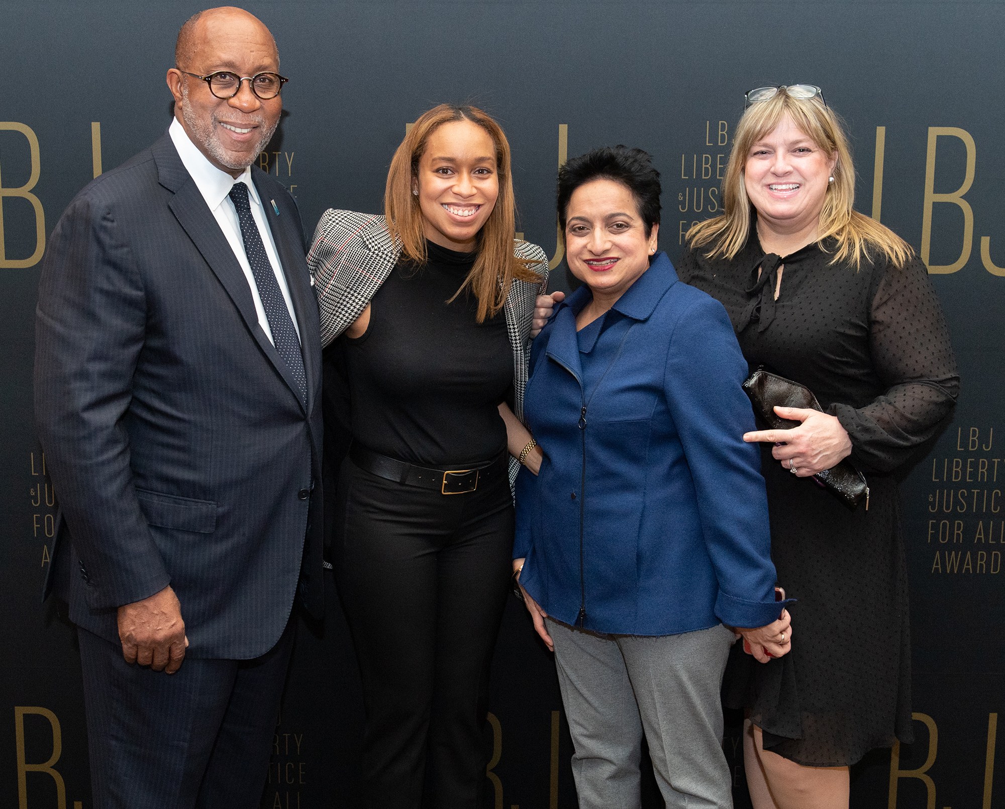 Vier Personen auf einem roten Teppich mit einem "Liberty Justice for All Awards"-Hintergrund