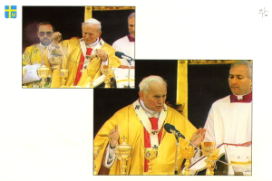 Papst Benedikt XVI. steht an einem Pult mit Mikrofon und feiert die Messe in der Petersbasilika, umgeben von mehreren Menschen im Hintergrund und einem Logo mit Text auf der linken Seite des Bildes.