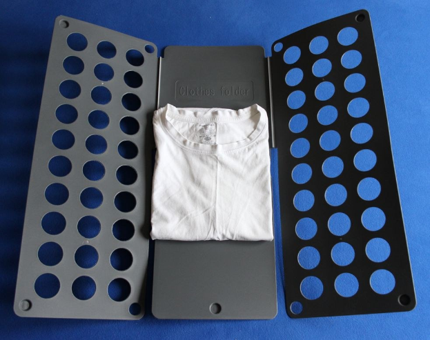 Weißes T-Shirt auf blauer Oberfläche neben schwarzem und aschgrauem Kleiderordner mit Löchern.