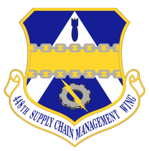 Logo des 48. Versorgungsmanagementflügels mit einem blauen Schild mit einem weißen Stern und einem weißen Banner mit der Aufschrift "Versorgungsmanagement" in blau, alles von einem weißen Rand mit schwarzem Text umgeben.