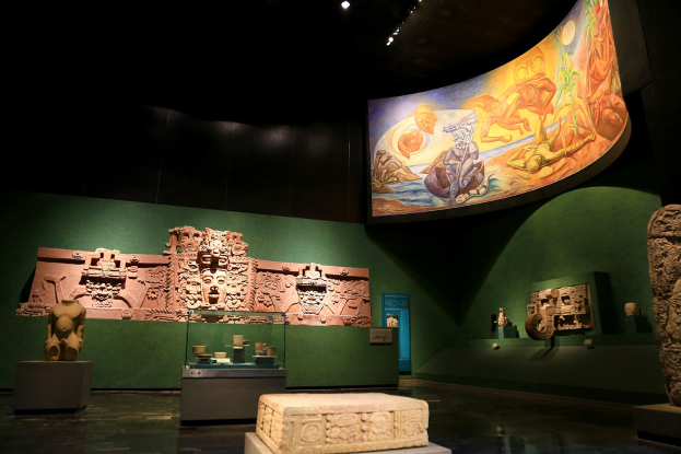 Ausstellung verschiedener Artefakte im Mexiko-Stadt-Museum der Anthropologie, darunter Skulpturen, Tischobjekte, eine Texttafel, eine Wandmalerei und Deckenbeleuchtung.
