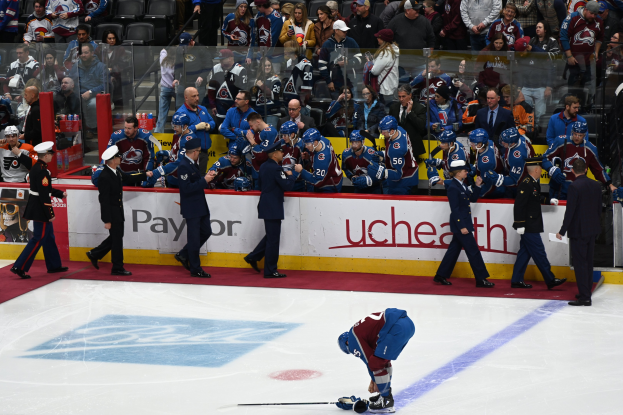 Eishockeyspieler auf dem Eis von Fans und Teammitgliedern umgeben während eines Spiels von Colorado Avalanche gegen San Jose Sharks am 24. März 2015.