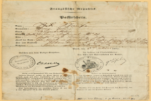 Ein altes, vergilbtes Dokument mit einem kreisrunden, schwarz umrandeten Stempel, das schwarze Tintenzeichen enthält, wahrscheinlich ein Brief der deutschen Regierung.
