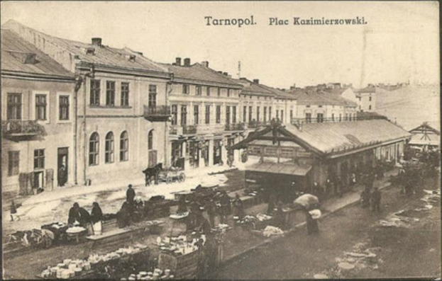 Altes Schwarz-Weiß-Foto eines vollen Marktes in Tarnopol, Polen mit Menschen auf Karren und Gebäuden im Hintergrund.